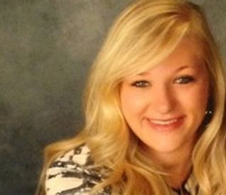 Smiling blonde woman with wavy hair.