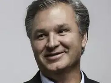 Smiling man with gray hair.