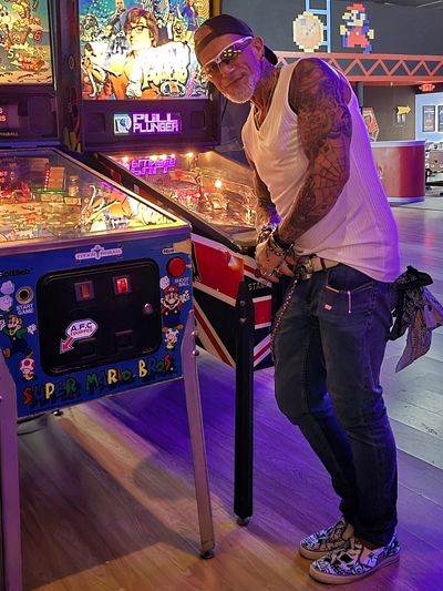 HIV/AIDS survivor Bob Bowers playing pinball, proving that aging with HIV doesn’t mean slowing down.