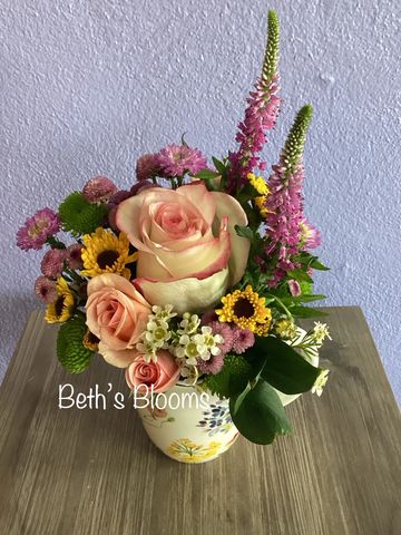 A colorful bouquet of mixed flowers in a floral vase.