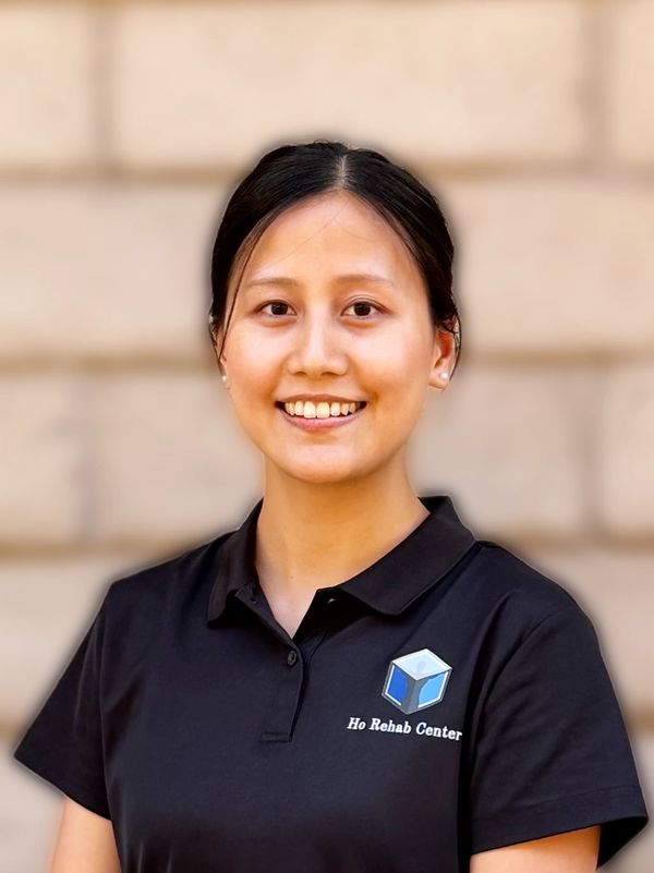 Smiling woman wearing a Ho Rehab Center polo shirt.