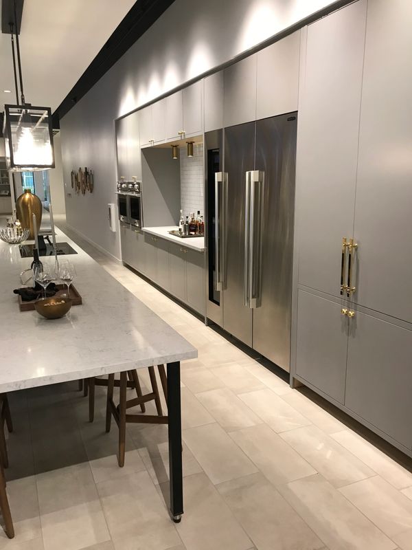 Modern kitchen with gray cabinets and stainless steel refrigerator.