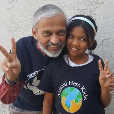 An elderly man and a young girl smiling and posing with peace signs.