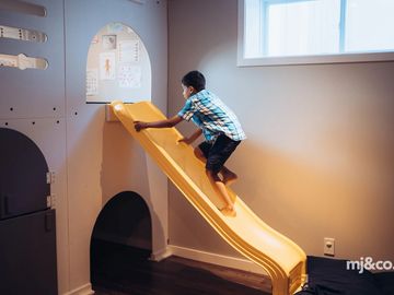 Child climbing slide in home