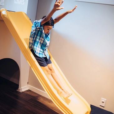 Child on slide in home
