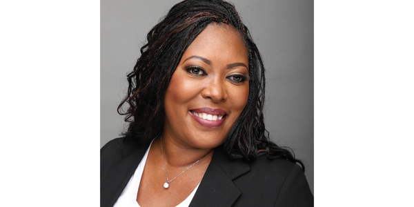 Confident woman smiling in a professional portrait with a black blazer.