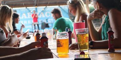 People at a table with drinks and a performer in the background.