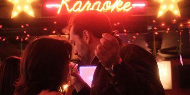 Couple sharing a moment in a karaoke bar.