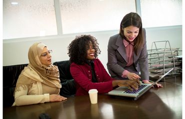 Three woman of color looking at the computer to illustrate diversity and inclusion