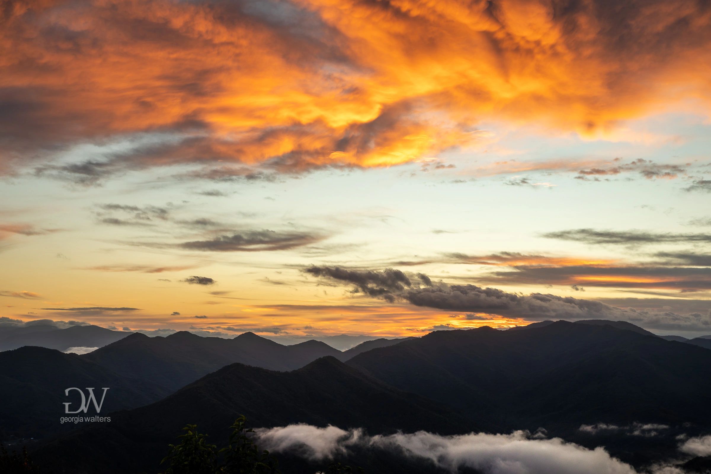 sunrise over a line of mountains on an early fall morning