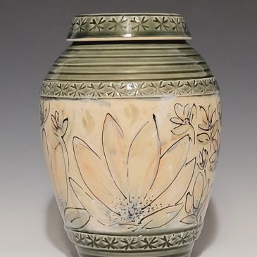 Decorative ceramic vase with floral patterns and green accents.