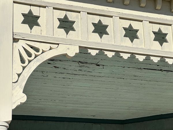 Decorative wooden trim with star cutouts on a porch ceiling.