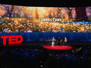 Three speakers on stage at a TED Talk titled Connectors.