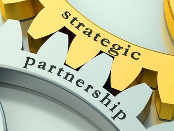 Interlocking gears labeled 'strategic' and 'partnership' symbolizing collaboration.