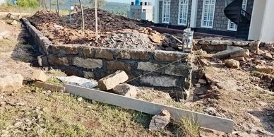 Foundation work with stone and concrete at a construction site.