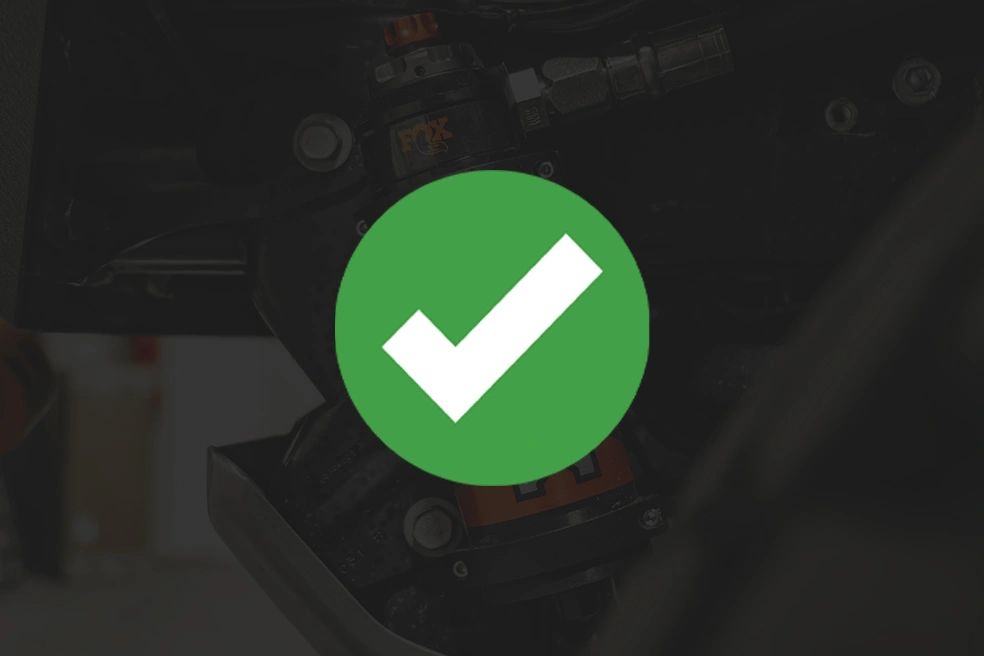 Green check mark symbol over mechanical parts background.
