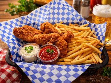 Fried chicken tenders with French fries and dipping sauces.