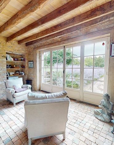 Living room in the Garden Cottage of the Château de La Motte-Feuilly with a view of the garden