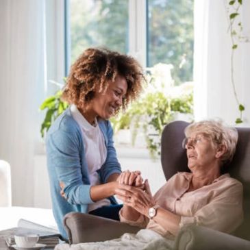 Nurses aide holding woman’s hands 