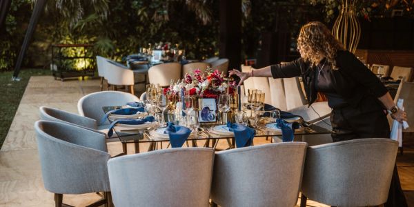 Mesa elegantemente arreglada con flores y copas en un evento.