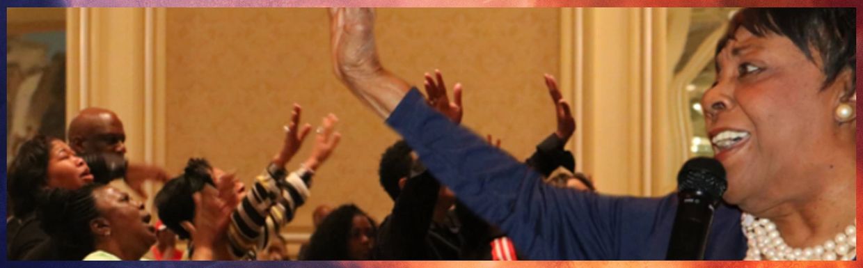 Dr. Mildred C. Harris encouraging the audience to give praises unto the Lord.