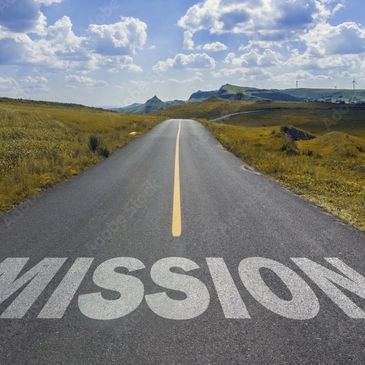 Long road ahead with 'MISSION' painted on the asphalt under a blue sky.