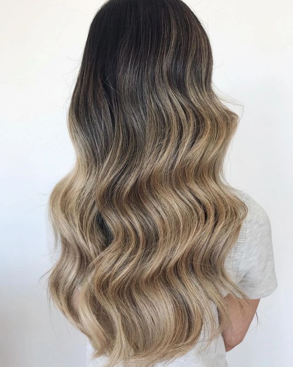 dark hair balayage wavy golden tones 