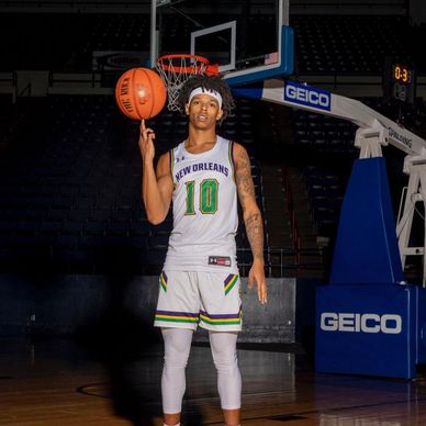 Basketball player in New Orleans jersey spinning a basketball on his finger.