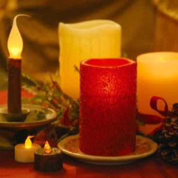 A cozy arrangement of candles and pine cones on a table.