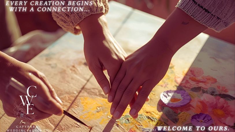 Two hands creating art together symbolizing connection and collaboration.