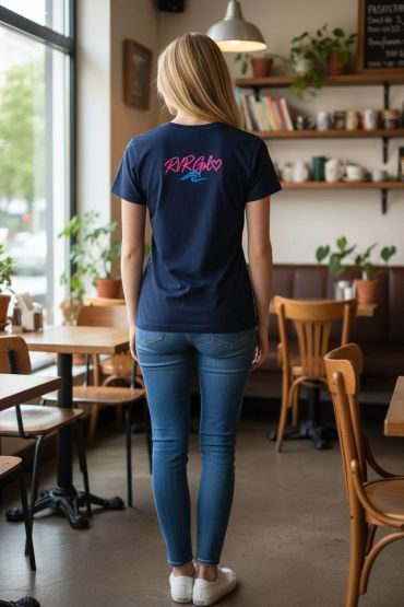 Woman standing in a cafe wearing a navy blue t-shirt and jeans.