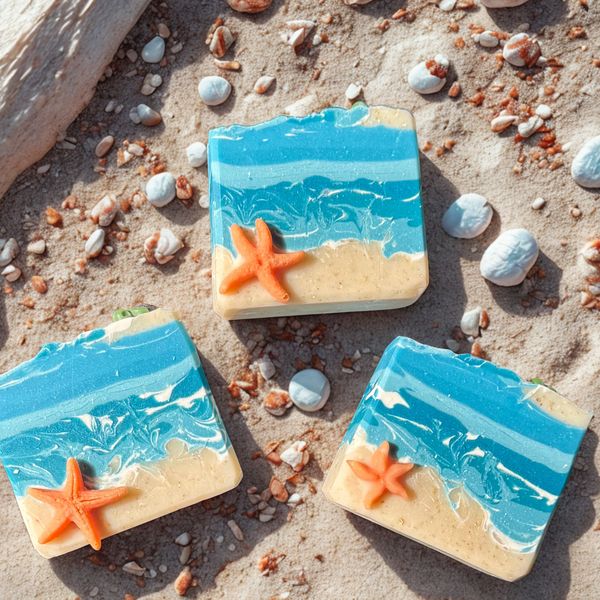 Beach-themed soaps with starfish on sandy surface.