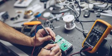 Felsökning och lödning av kretskort med multimeter i verkstaden