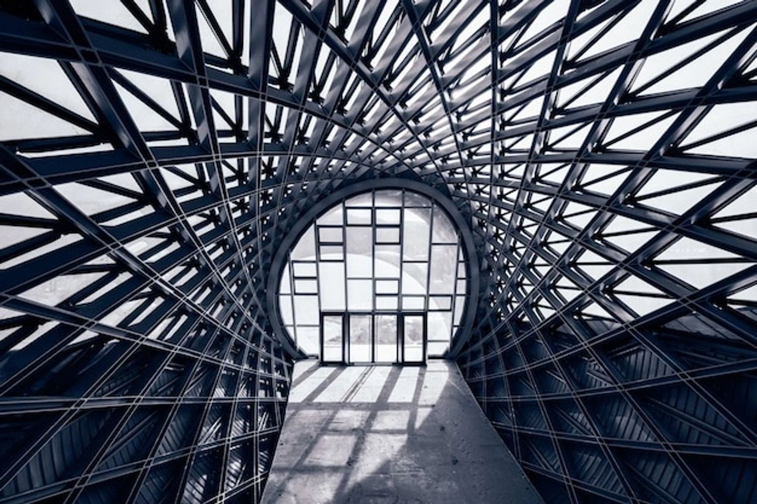 Futuristic spiraled metal and glass structure with geometric patterns.