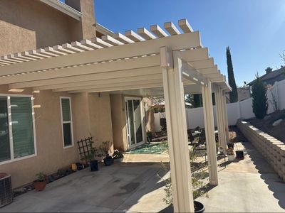 Backyard patio with pergola and potted plants.