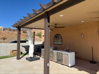 Covered outdoor patio with a mini fridge and bar setup.