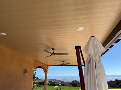Covered patio with ceiling fans and umbrella.
