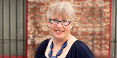 Allison Almond - The Organization Maven a headshot photo in front of a brick background
