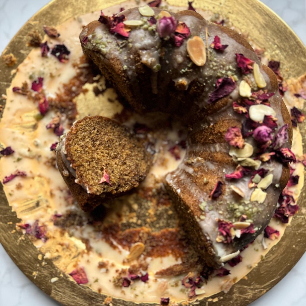 A beautifully fragrant rose karak tea cake decorated with almonds and rose petals 