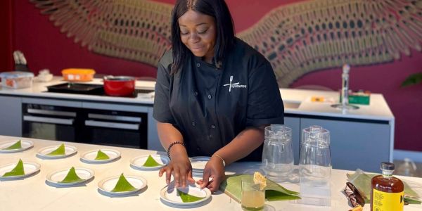 Chef preparing plates with green triangular desserts in a modern kitchen.