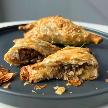 Golden puff pastry pies containing lamb and plantain