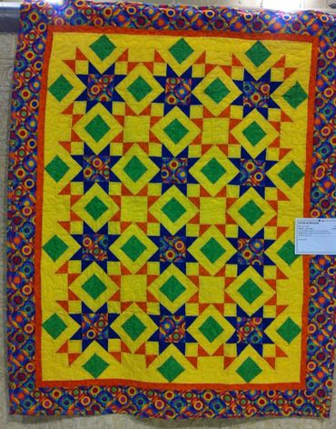 Colorful patchwork quilt with geometric patterns in blue, green, yellow, and orange.