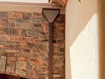 Outdoor wall light fixture on stone wall.