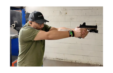 Man aiming a handgun at a shooting range.