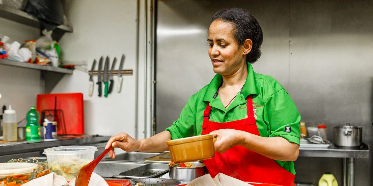 a woman in green top cooking food 