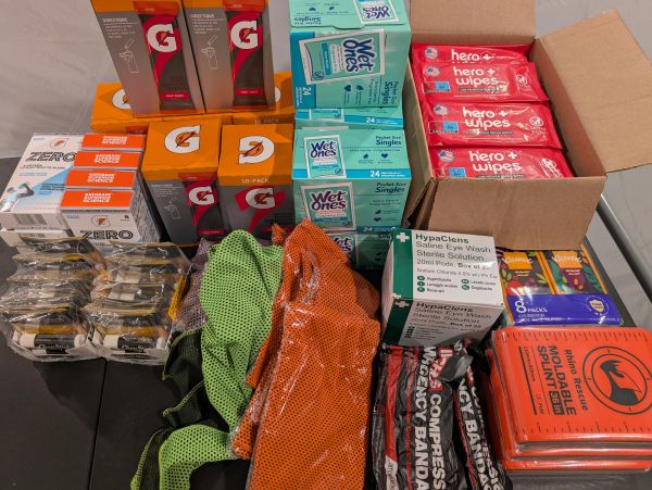 Emergency supplies including drinks, wipes, bandages, and splints organized on a table.