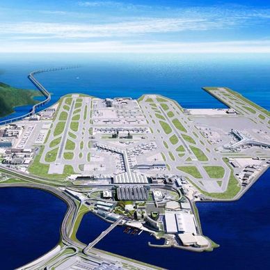Aerial view of a large airport on a coastal area with multiple runways and terminals.