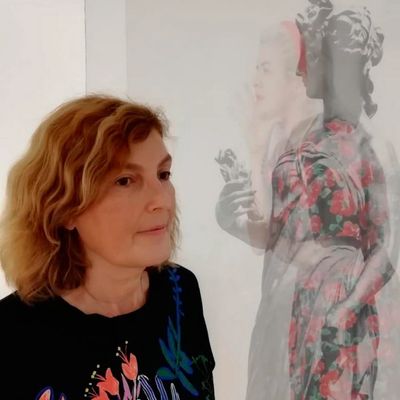 Mujer observa una pintura con doble imagen surrealista.