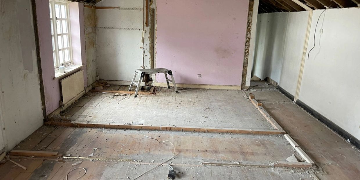 Room under renovation with exposed floors and walls.