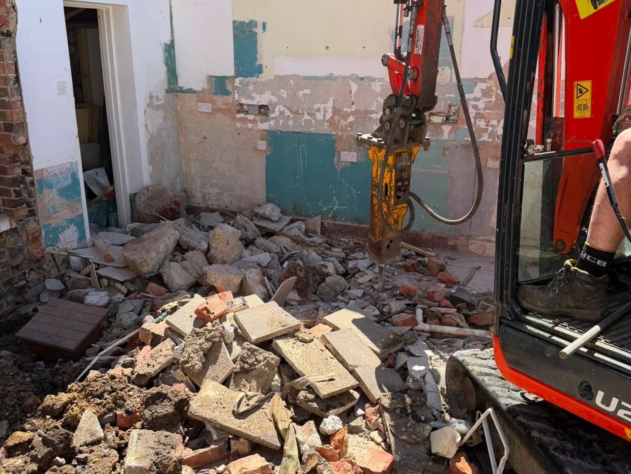 Room demolition with rubble and machinery.